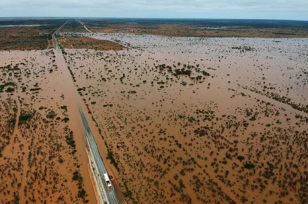 Floodwaters shown in this aerial view of the Nullarbor have now receded, the train line can be seen at the right of ARTC's picture adjacent to the highway.