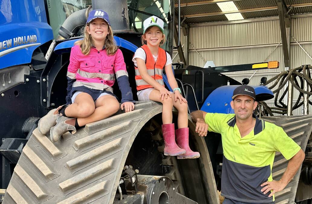 Evie and Isabelle Dolton with dad Stephen during seeding last week.