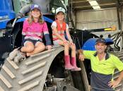 Evie and Isabelle Dolton with dad Stephen during seeding last week.