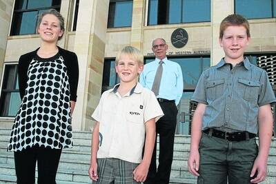 Agricultural Region MLC, Jim Chown (back), with the three winners of his inaugural Design a Christmas Card competition, Elise Norrish (left), Kojonup District High School; Logan Purser, Moora Primary School, and Jaxon Lantkze, Gnowangerup District High School, in front of Parliament House.