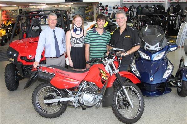 Tom Kerse (centre), Muntadgin, with his girlfriend Lisette Pieke, Netherlands, Farm Weekly publisher Trevor Emery (left) and Revsports principal Steve Ford, Victoria Park, was happy to finally be able to collect the Honda CTX200 Bushlander motorbike he won in Farm Weekly's recent subscriber competition.