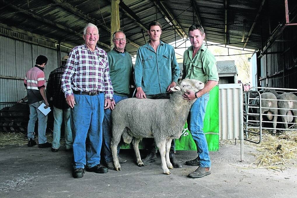 Sandown stud co-principal Graham Sutherland (left), with Ian and Dale Phillips who paid the sale&#39;s top price of $1700 for this ram held by Landmark Badgingarra livestock agent Greg Wootton.