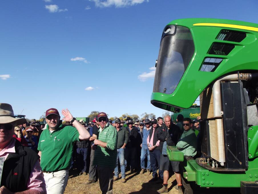  Landmark auctioneer Terry Norrish (left), found the bids were coming from all directions, but was still able to knock this John Deere 9620 down for the day's top price of $195,000.