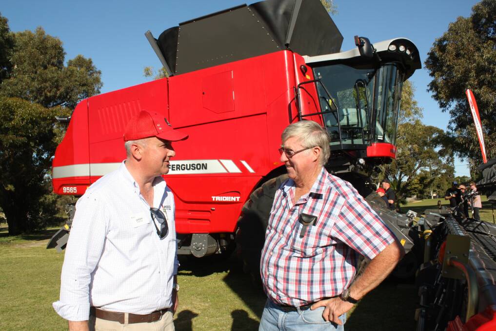 AGCO area sales manager Jason Hayes (left) with Mullewa farmer Peter Dean in front of the Massey Ferguson 9565 combine harvester.