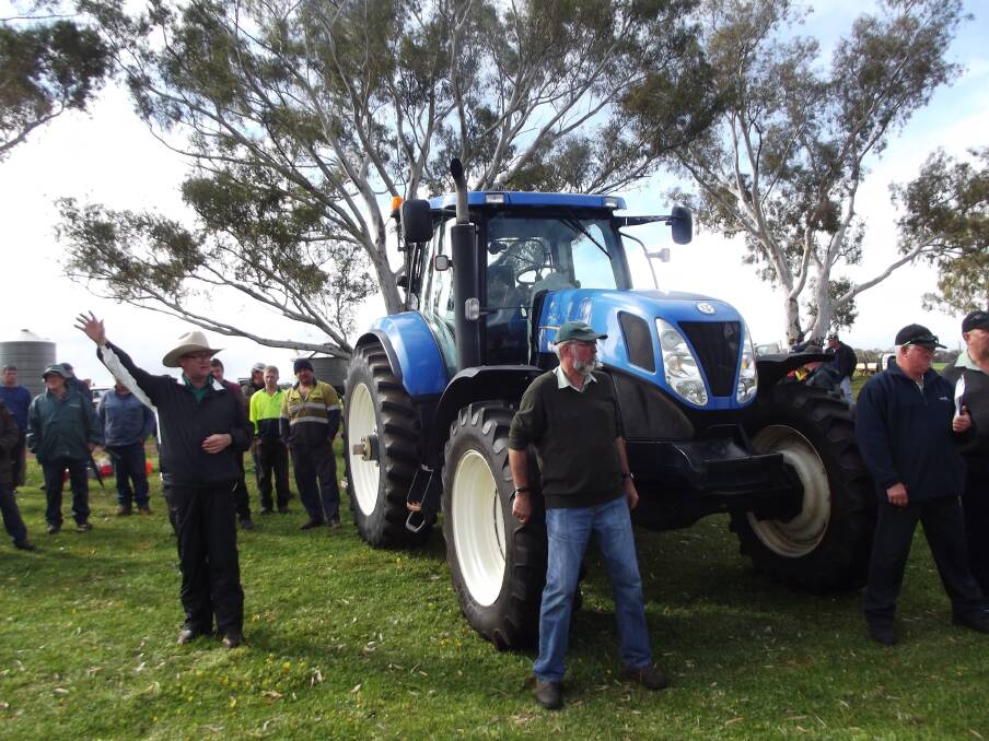 Landmark auctioneer Tiny Holley (left) was at his loquacious best as he knocked down this NH T7050 tractor for the day's top price of $69,000.