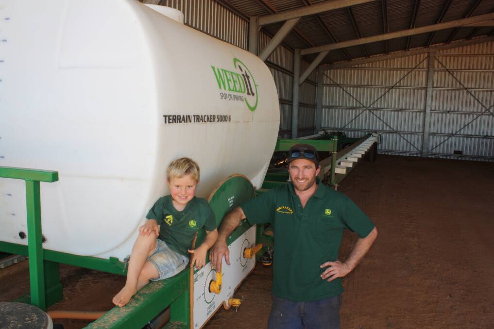 Nick Priest and his son Lincoln make sure the "28s" are not chewing wires on the Weedit sprayer last week. See lead story.