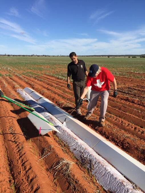 Dr Raju Adhikari (left) and George Freischmidt from the CSIRO apply the water-based polymer to the soil as part of a trial in the eastern Wheatbelt by DAFWA to test the product in dryland broadacre farming.