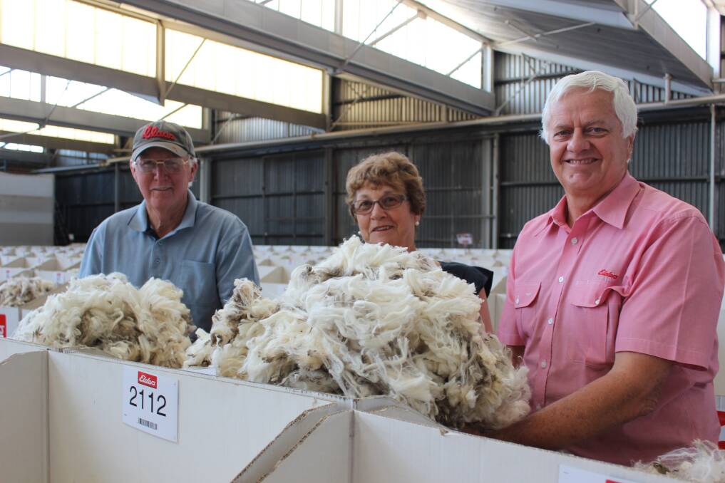 Murray (left) and Erin Hall, Purpareena, Tenterden West, inspecting their clip samples on the Elders show floor with wool broker Rob Young.