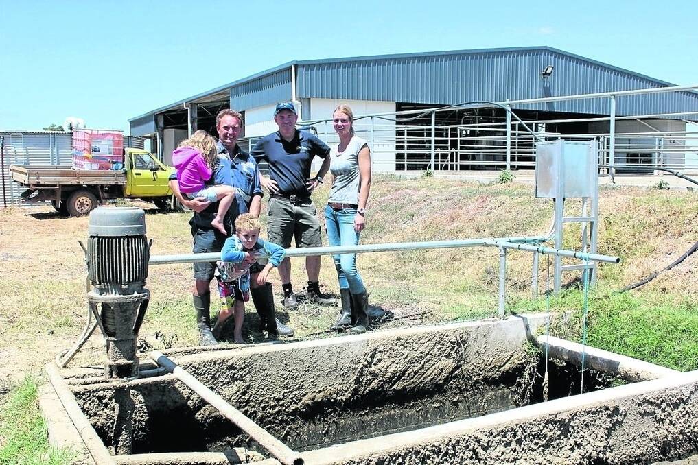 Dardanup dairy farmer Michael Twomey holding shy daughter Nyah, 5, his son Michael, 6, Western Dairy project officer Dan Parnell and environmental engineering student Laura Senge inspecting the effluent system.