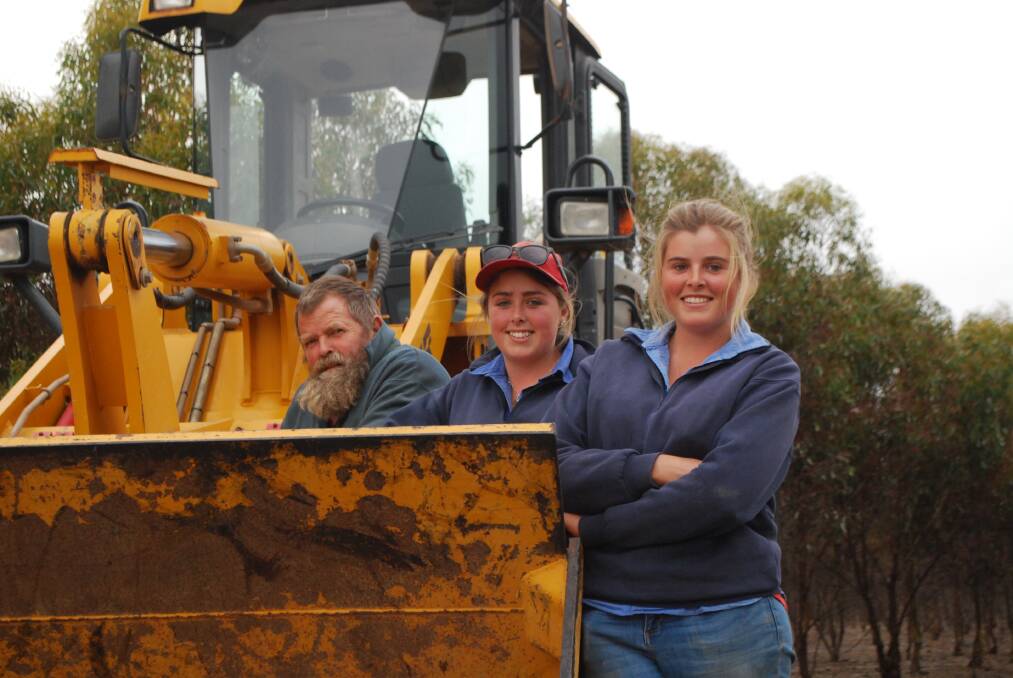 John Fagg, Raventhorpe, with daughters Emily and Coralie, with the front end loader that sold for $57,000 to a Manjimup farmer at the RELM clearing sale.