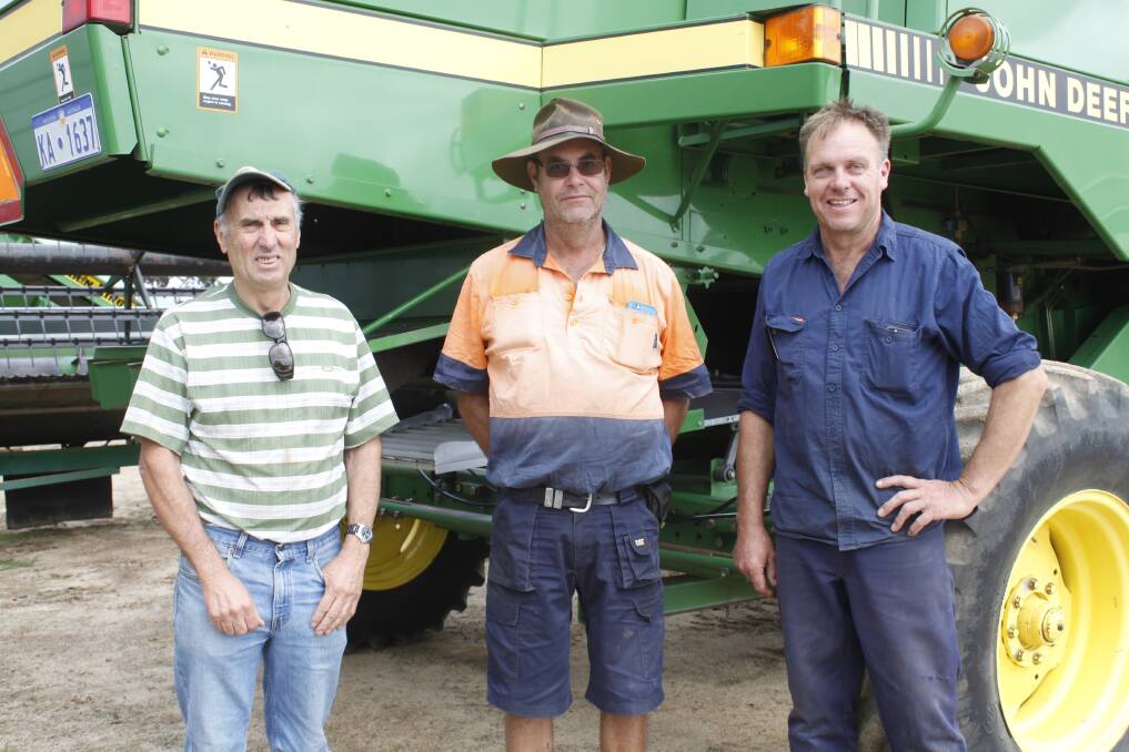 Tambellup farmers Mark Diprose (left), Richard Burridge and Kim Oliver looked over the John Deere CTS header which sold for $21,000.