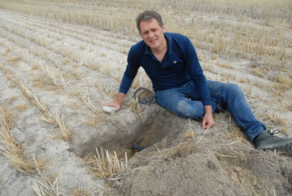 DAFWA research officer Dr Steve Davies measures the soil moisture content of water repellent soil that has been rotary spaded at a Meckering trial site. Dr Davies warns deep ripping will not necessarily overcome soil water repellence.