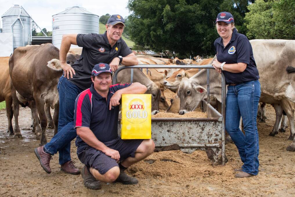 Lion suppliers Ray and Catherine De Vere, who farm west of Nambour on Queensland's Sunshine Coast, with their cows sampling brewers' grain from Lion's XXXX brewery, and Lion farm services officer Cameron Whitson, who is poised to shout them a beer.