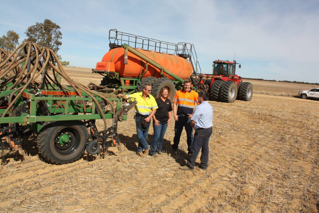 Pictured with Boekeman Machinery salesman Wayne Stoner (right) are East Latham farmers Mark Wilson (left), his wife Suzanne and son Tom.