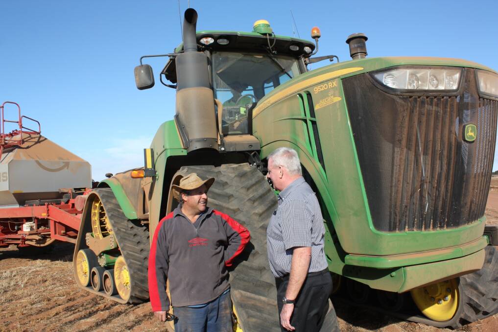Wubin farmer Garry Cail (left) and AFGRI Dalwallinu ag sales manager Ray Trinder discuss Garry's new purchase, a John Deere 9520RX track tractor.