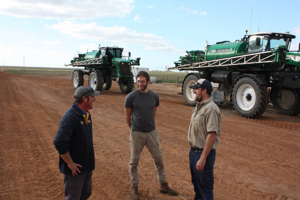 Staines Esperance salesman Brad Gray (left), sprayer driver Sven Hochhausler, Germany and Lort River farmer John Stead discussing the farm's two Goldacres self-propelled boomsprayers.