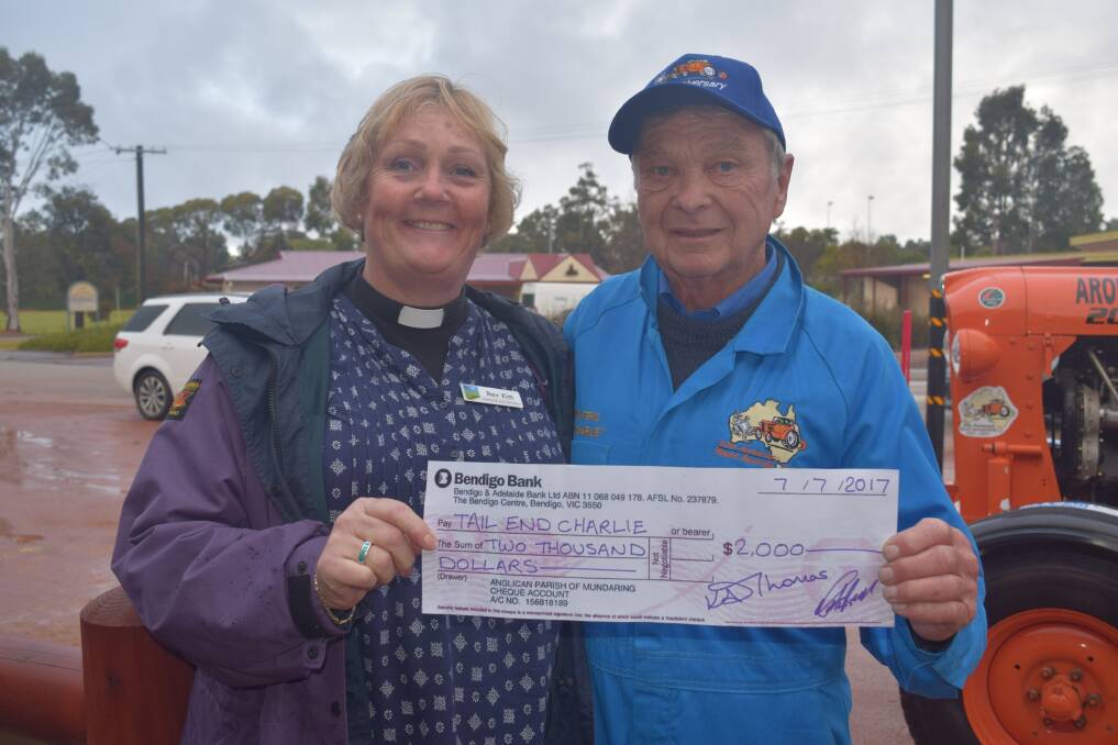 Reverend Kim Thomas (left), Mundaring and Wooroloo Anglican Church, hands a $2000 cheque to Ron Bywaters.