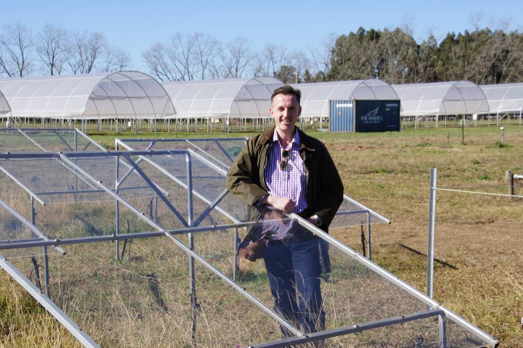 Dr Scott Johnson with a rain exclusion shelter that is being used in early research of silicon and grasses. A variety of shelters are used to deliver pasture a range of rainfall patterns.