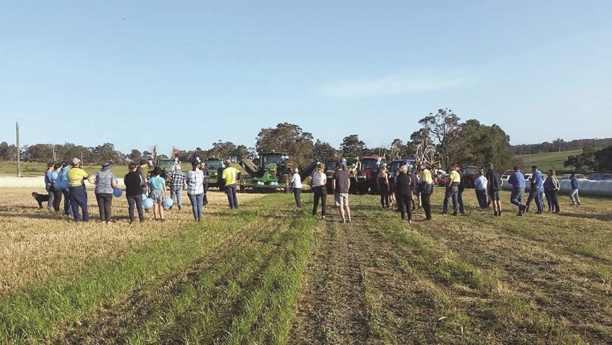 Volunteers gather after helping rake, bale, transport, wrap and stack 930 bales of silage for Busselton dairy farmer Brett Milner who is facing surgery for prostate cancer and being unable to work his farm for three months.