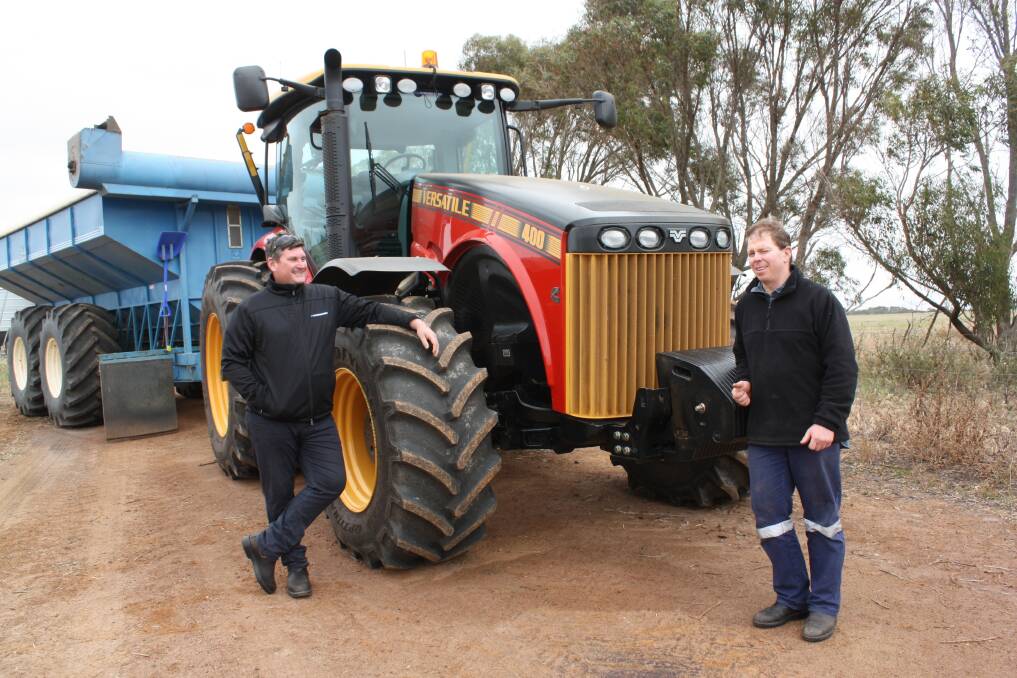 McIntosh & Son salesman Dan Tracey (left) and Bedford Harbour farmer Warren Saunders discuss the performance of Warren's new Versatile 400 front-wheel-assist tractor which is getting its first outing as a chaser tractor during a rain-interrupted harvest. 