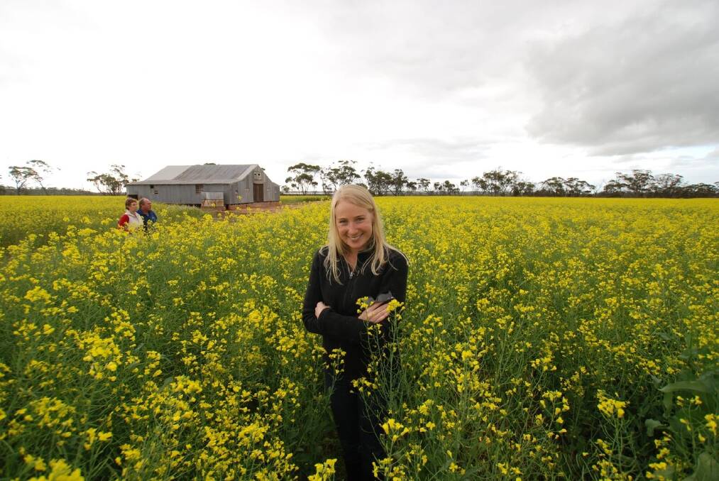 Christie Stewart with her parents Karen and John Stewart in a canola field when the family farmed at Wongan Hills.