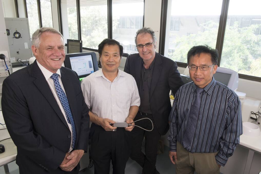 Grains Research and Development Corporation senior regional manager Charlie Thorn (left) and Department of Primary Industries and Regional Development (DPIRD) senior research officer Hua'an Yang, managing director research, development and innovation Mark Sweetingham and principal research officer Chengdao Li with a DNA sequencer. 