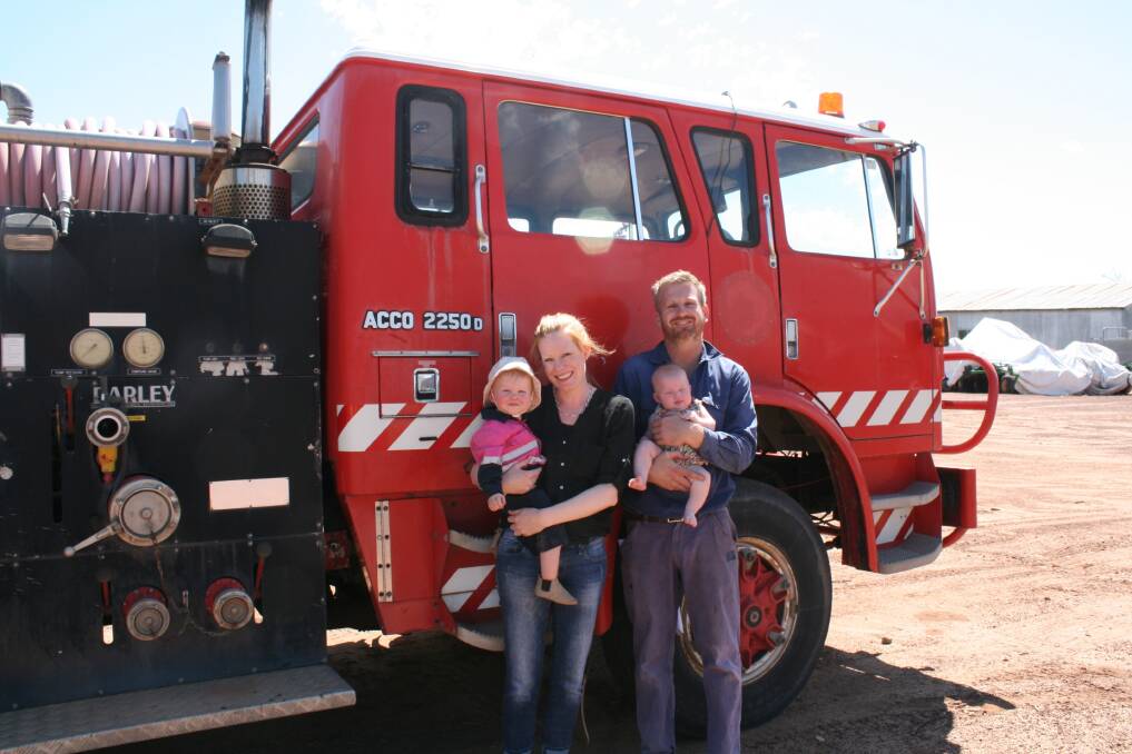 Em Fulwood (left), holding daughter Sylvie (1) and her husband Ty with their second daughter Eugenie (3 months) in front of the maintenance truck as they get everything ready for the year ahead on their Southern Brook property.