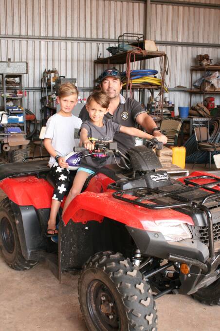  Eight-year-old Ky South (left), with brother Jarryn (6) and father Clayton as they spend the last week of school holidays on the farm.
