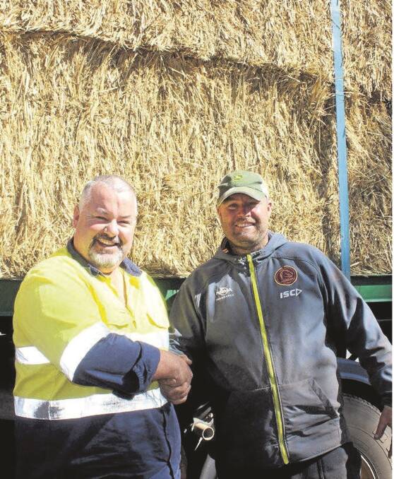 WA truck driver Norm Mundy (left) delivers much-needed hay to dairy farmer Ashley Gamble, Oakey, Queensland.