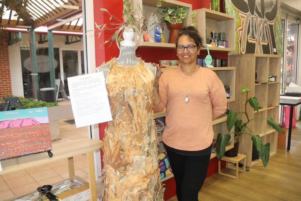 Artist, artisan and designer Sammy Wyborn at her Swan Valley art gallery, art school, gift shop and cafe with a dress made by another indigenous designer from the bark, seeds and nuts of a broad leaf paperbark tree. Ms Wyborn is planning to launch a fashion line in August with a model wearing this dress.