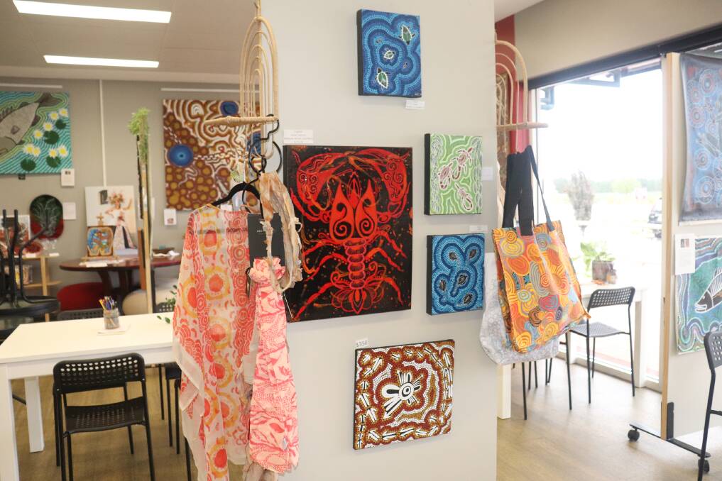 Colourful shawls, tote bags and bum bags fight for attention with vibrant paintings.