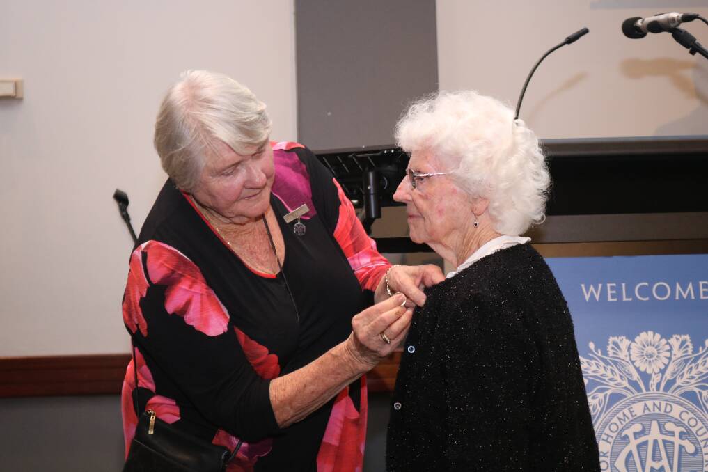Wendy Ayers (right), formally receiving her honorary life membership badge from Anne Gething, after she was unable to received the award last year.