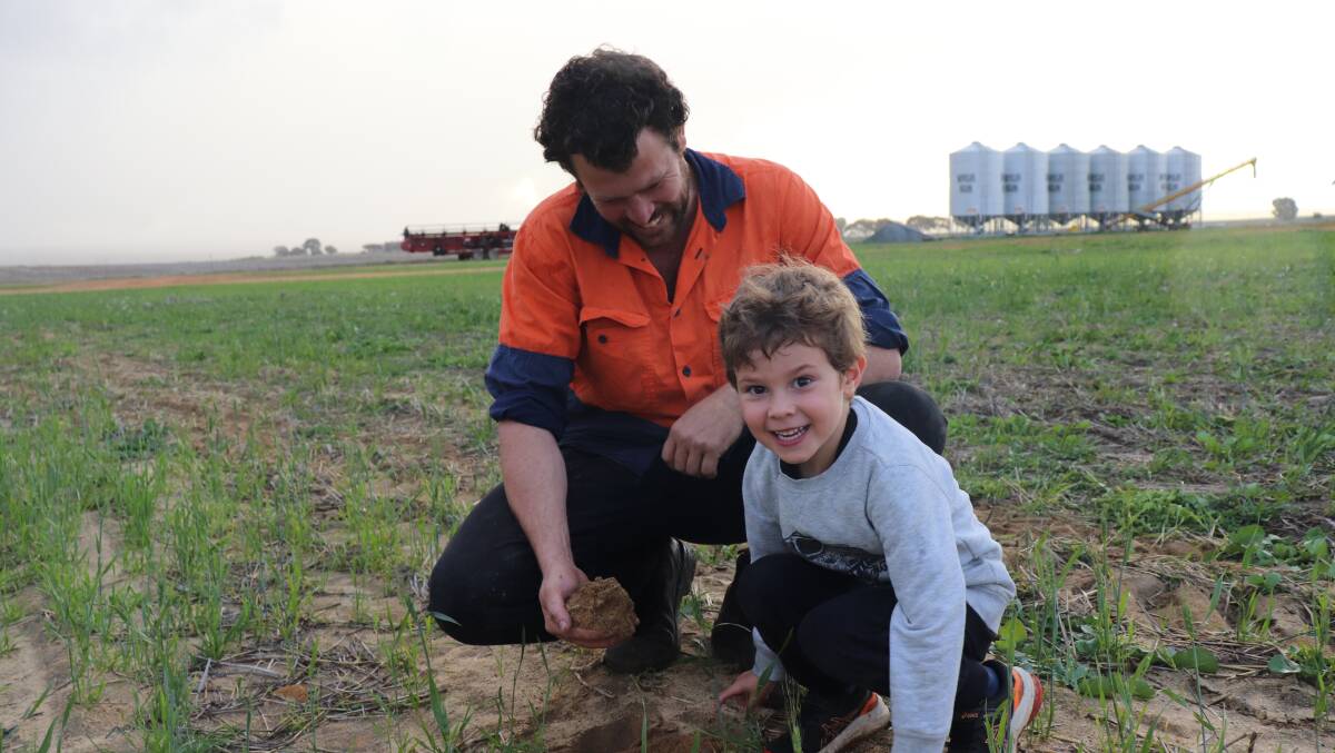 Ashley Bone and son Liam, 4, looking at the soil profile the farm has a mixed soil type from good yellow loamy sand to pretty horrible white sand, as well as good gravel country, red loam and red clay.