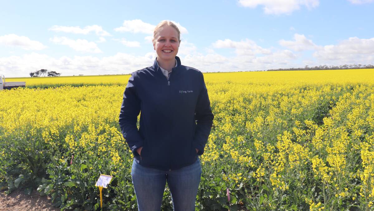 Living Farm research agronomist Chloe Rout in front of her canola trial comparing results with and without soil wetters.