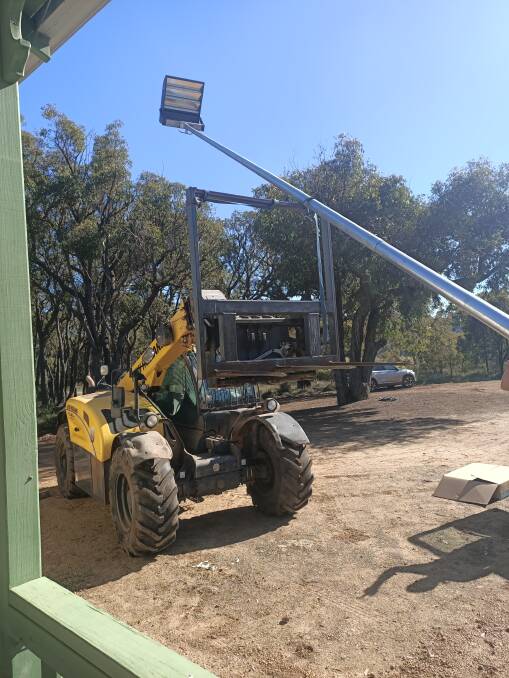 The installation of lighting towers at the Kendenup Tennis Club last year. The new lighting has helped the club recruit more members.