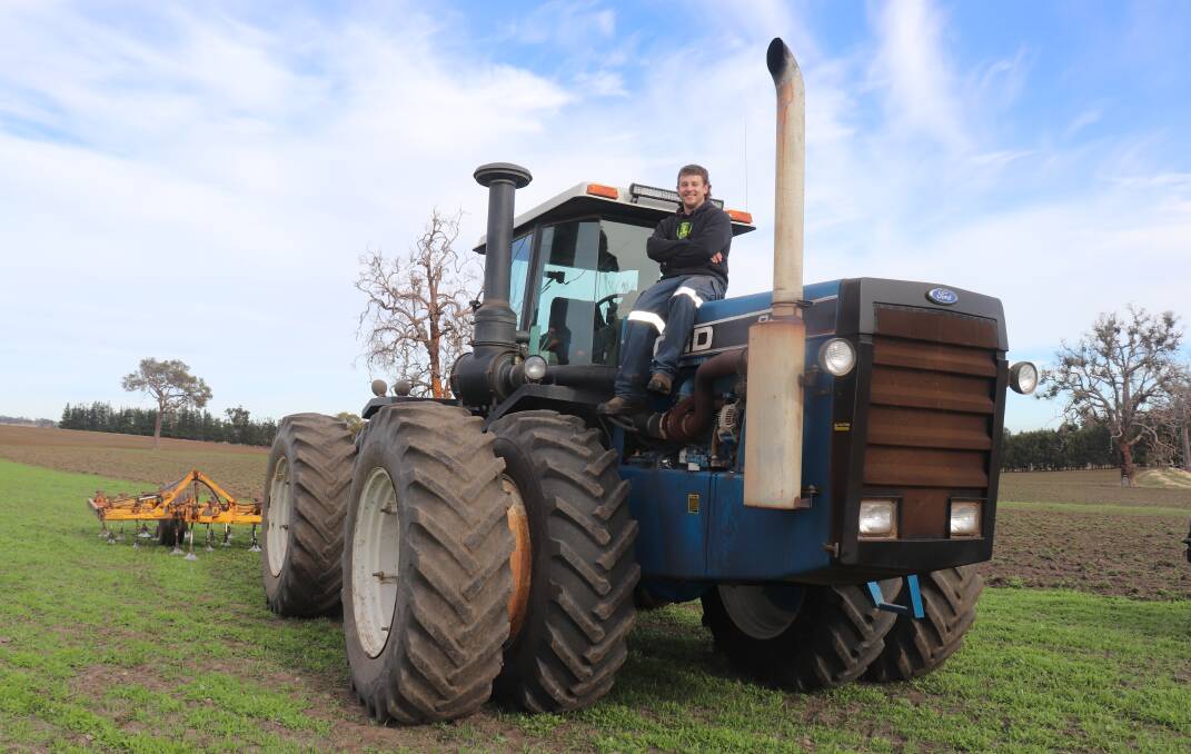 Michael Graham with one of his best buys, a 1990 four-wheel-drive Versatile 846 tractor with 230 horsepower Cummins motor and manual gearbox that he has used for most of the heavy work preparing the ground for his first crop.