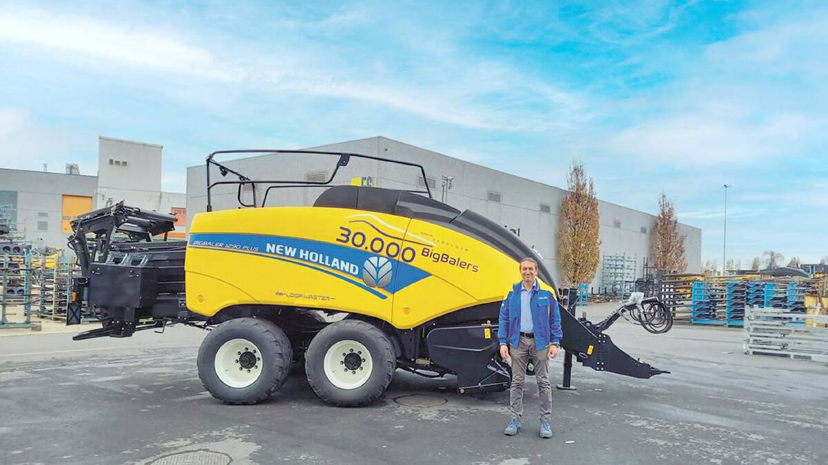 Luigi Neirynck, New Holland plant manager at Zedelgem, Belgium, stands with the 30,000th large square baler rolled off the line at the Zedelgem Centre of Harvesting Excellence.