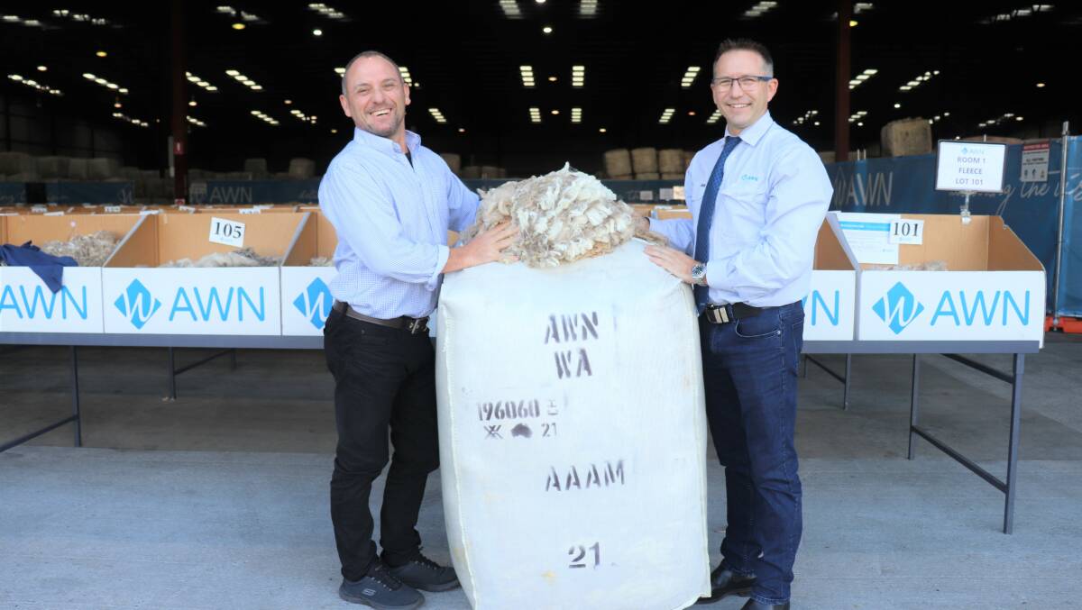 Endeavour Wool Exports' Western Australian buyer Steve Noa (left) and Australian Wool Network's State wool manager Greg Tilbrook with the bale and a sample of the wool inside it, which raised more than $2000 for the Royal Flying Doctor Service.