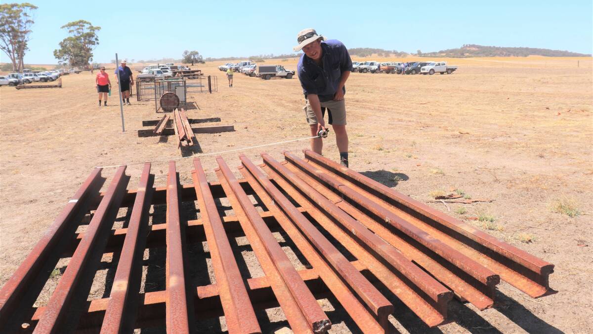 Matt Chambers, Boyup Brook, measures up a stock grid made from old railway line to make sure it will fit on the trailer before he bought it with a winning bid of $1600.