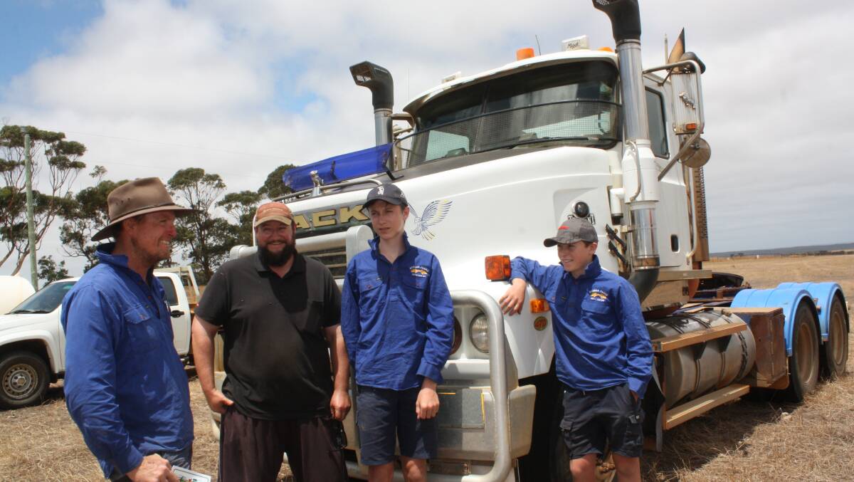 Hopetoun farmers Stott Redman (left) and Ashley Witt discuss the features of this 2005 Mack Trident prime mover with Stott's sons Darcy and Beau. The licensed unit, put up by an outside vendor, had chalked up 982,000 kilometres and came with side tipper hydraulics. It was later passed-in after an opening bid of $10,000.