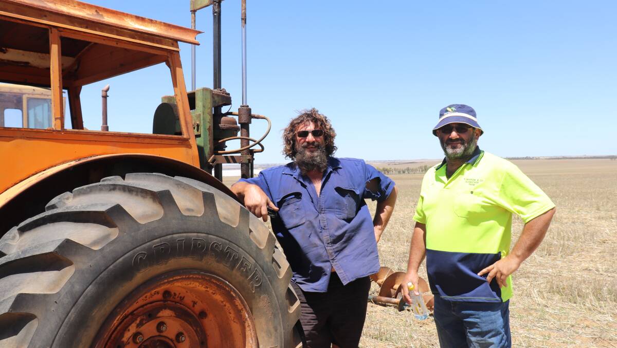 Farmers looking for cheap chaser-bin tractors checked out four older Chamberlains on offer, which all sold. Brothers Nick (left) and John Marrone, Wubin, looked over this Chamberlain Countryman 6 tractor with Pizey post hole digger. It sold for $10,000.