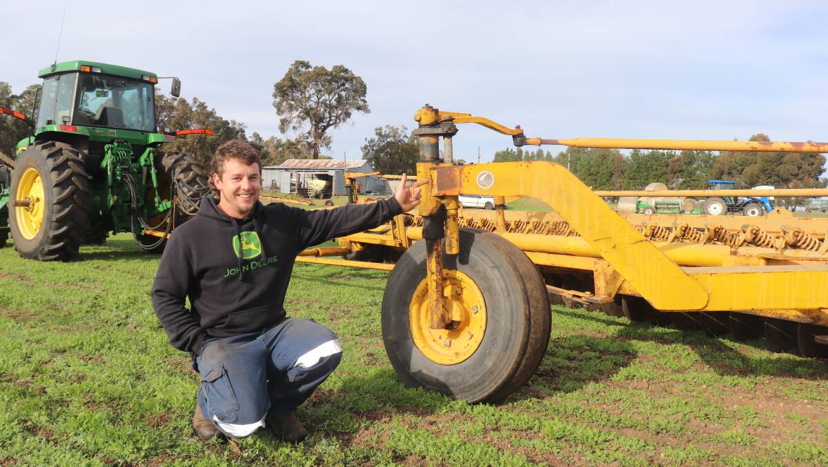 Michael Graham points to the faded 'Made in Australia' sticker on the frame of the Chamberlain 30-disc one-way plough he used to prepare the ground for his first crops.