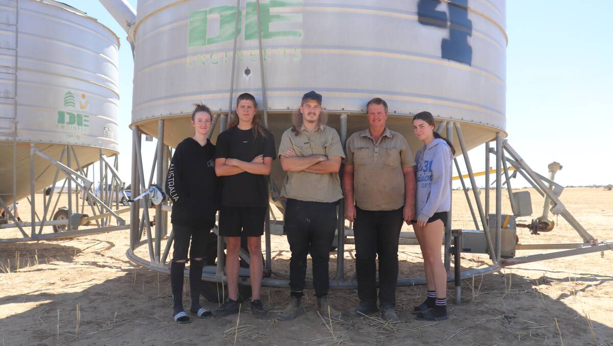 Sheltering in the shade of a 45 tonne DE Engineers field bin that sold for $7000 are Jess Sudholz (left), Meckering, Ryder Donegan, Northam, Daniel Sudholz, Darryl Sudholz and Hannah Sudholz, all of Meckering.