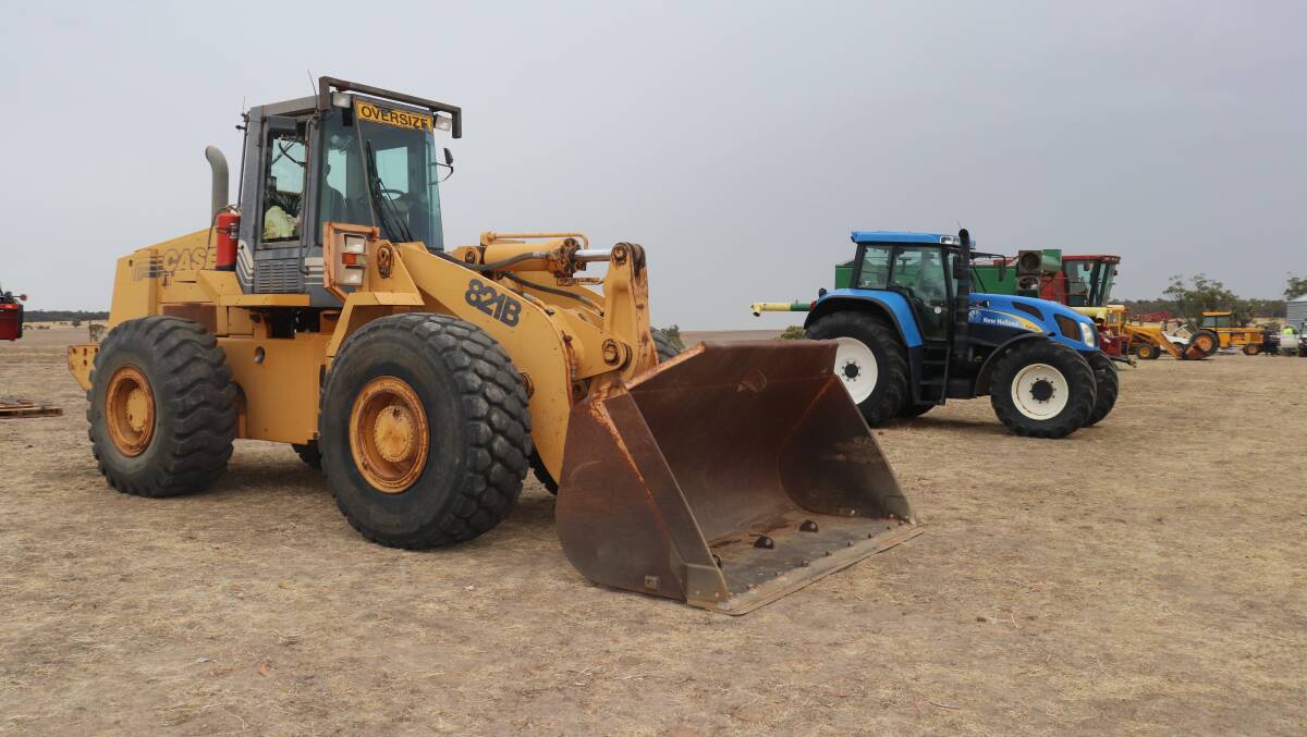 Side by side with a sprinkle of rain approaching, the two top items of the East Beverley clearing sale, a 1990s 16 tonne Case 821B wheel loader which sold for $74,000 and a 2006 New Holland TVT 155 front-wheel-assist tractor which sold for $54,000.