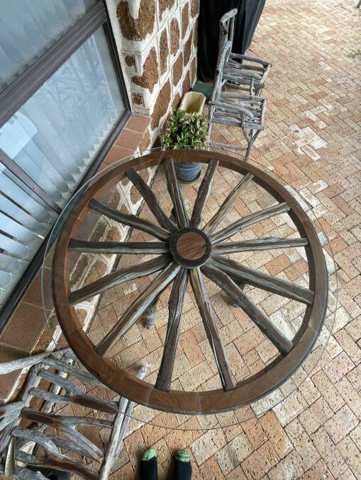This wagon wheel has a glass top on it, making it a unique table.