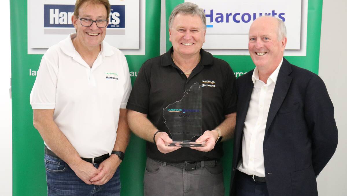 Landmark Harcourts real estate manager for west region, Glenn McTaggart (left) and sponsor, WA Property Lawyers principal Brian McCormack (right) congratulated Neville Tutt on winning the Landmark Harcourts silver achievement award for second place in overall sales for 2018-19.