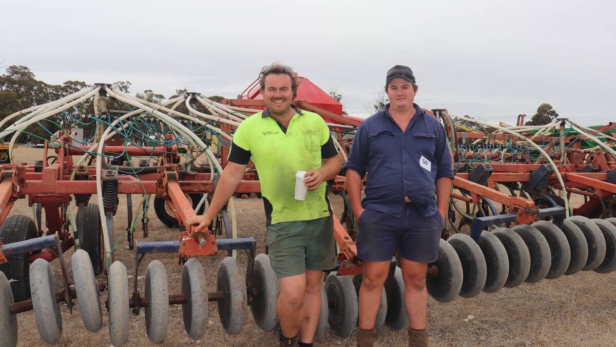 Rhys Muir (left), Mardella and Chris Darke, Boyup Brook, with the Morris air seeder rig that later sold for $10,500.