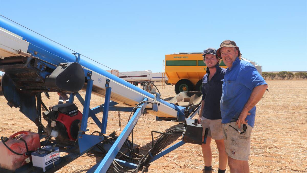 Tom Steber (left), Doodlakine and his father Matt, check out the 13.7 metre self-propelled Brandt 1545 grain belt truck loader which sold for $35,000.