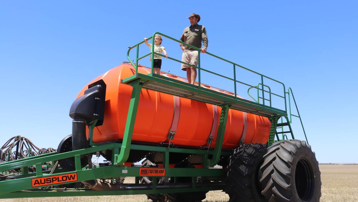 Hugo, 3, and dad Alan Seymour, Miling, inspecting the 2011 Ausplow M18000 Multistream air cart that was initially passed in at a bargain price of $335,000 as a combined unit with the 2009 18.2 metres (60ft) Ausplow DBS D-260 seeder bar with DBS air kit beside it. Put up separately, the Multistream was then passed in without a bid at $100,000. It was then sold privately before the auctioneer had completed selling the next two lots.