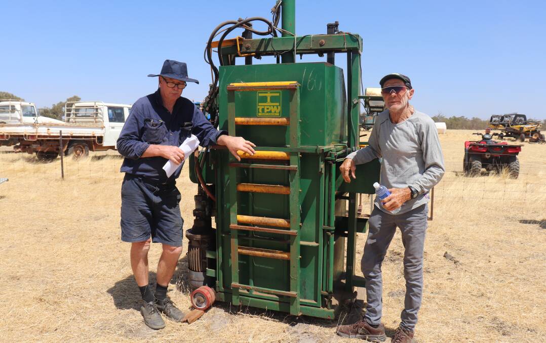 Greg Reid (left), Esperance, and Paul Price, Hyden, looking at a wool press that later sold for $13,000.